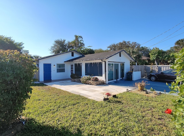 rear view of property featuring a yard and a patio