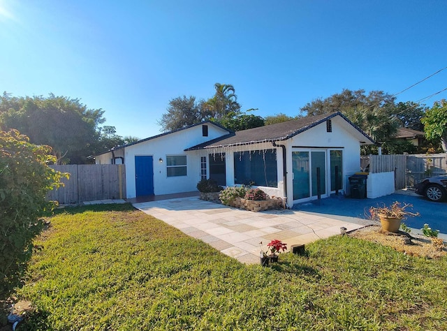 back of property with a patio area and a yard