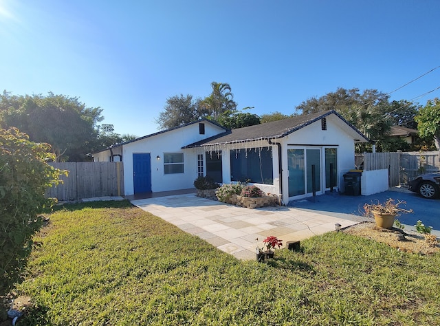 back of property with a yard and a patio area