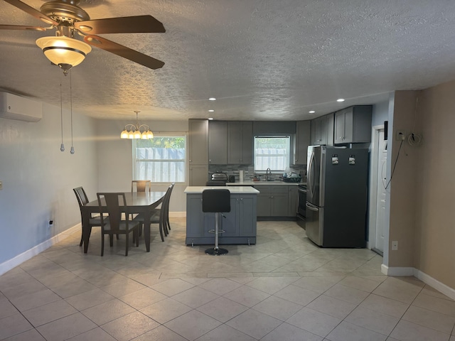 kitchen with stainless steel appliances, a kitchen island, gray cabinetry, and sink