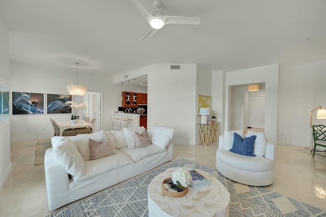 living room with ceiling fan with notable chandelier