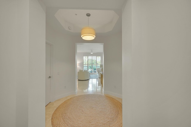 hallway featuring a tray ceiling