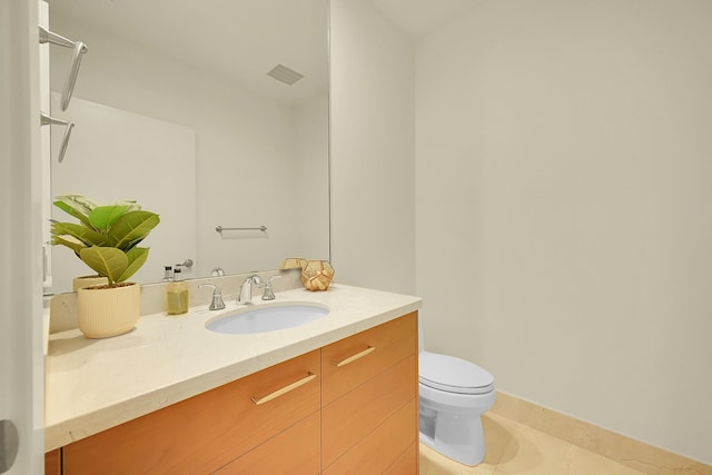 bathroom with tile patterned flooring, vanity, and toilet