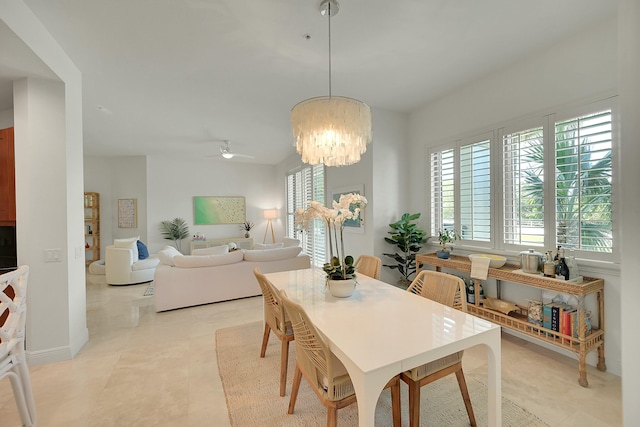 tiled dining area featuring ceiling fan with notable chandelier