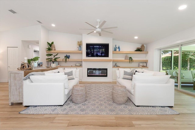 living room with ceiling fan, lofted ceiling, and light wood-type flooring