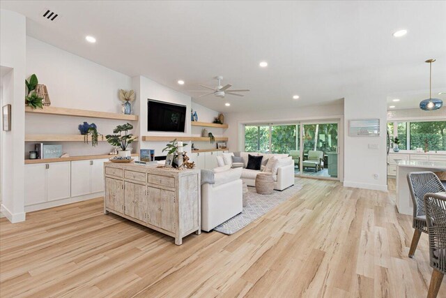 living room with vaulted ceiling, recessed lighting, light wood-type flooring, and a ceiling fan