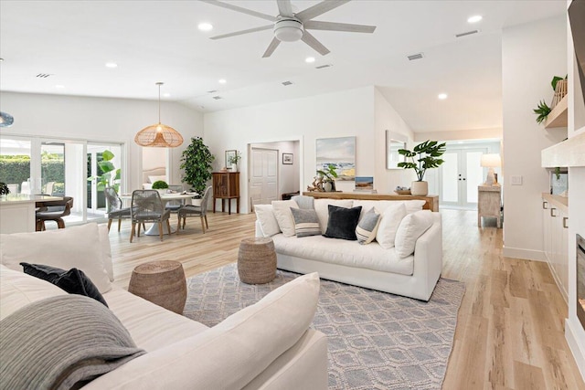 living room with ceiling fan, light hardwood / wood-style floors, vaulted ceiling, and french doors