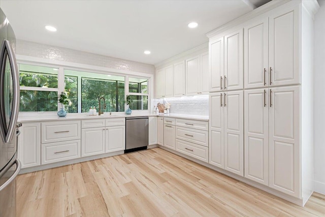 kitchen with sink, white cabinets, stainless steel appliances, and plenty of natural light