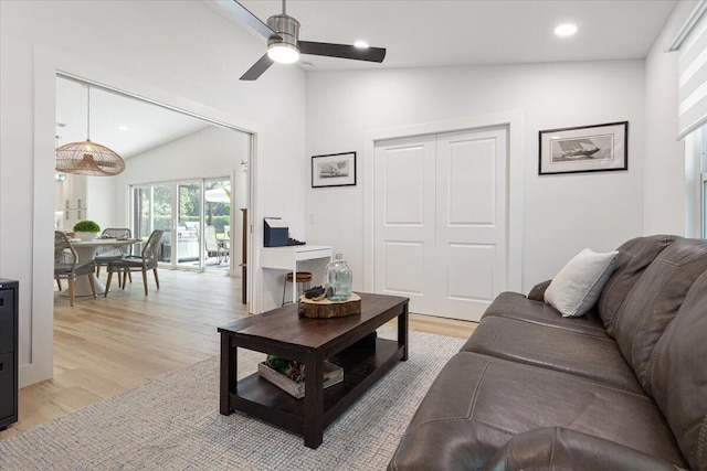 living room with ceiling fan, light hardwood / wood-style flooring, and lofted ceiling