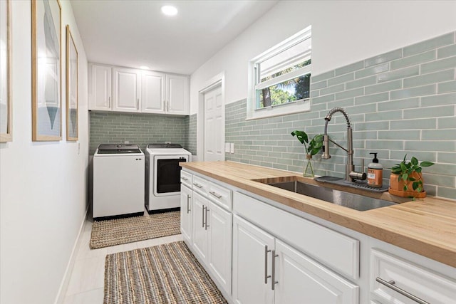 kitchen with white cabinetry, sink, separate washer and dryer, wooden counters, and light tile patterned flooring