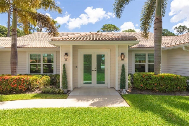 property entrance featuring a lawn and french doors