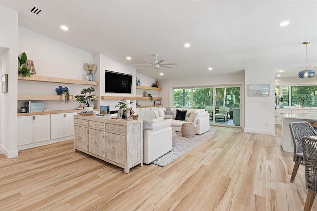 living room featuring ceiling fan, light hardwood / wood-style floors, and vaulted ceiling