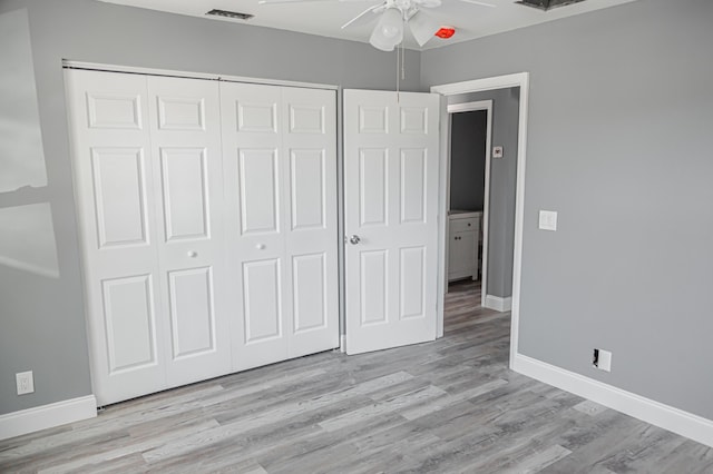 unfurnished bedroom featuring ceiling fan, light wood-type flooring, and a closet