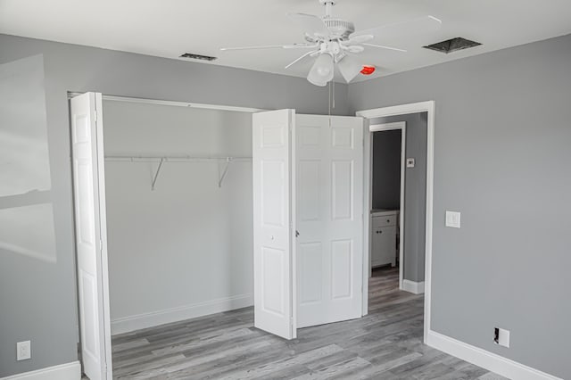 unfurnished bedroom featuring ceiling fan, light hardwood / wood-style flooring, and a closet