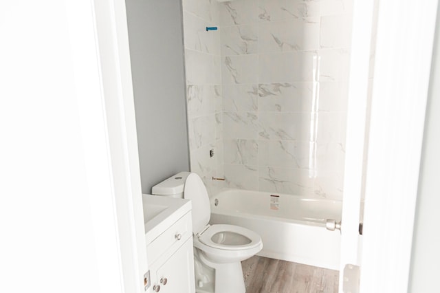 full bathroom with hardwood / wood-style flooring, vanity, toilet, and tiled shower / bath