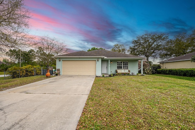 single story home with a yard, stucco siding, an attached garage, fence, and driveway