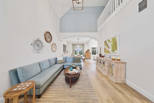 living room featuring a high ceiling and light wood-type flooring