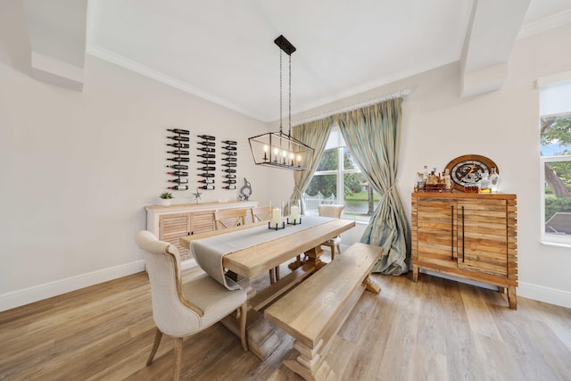 dining space with a notable chandelier, light wood-type flooring, and crown molding