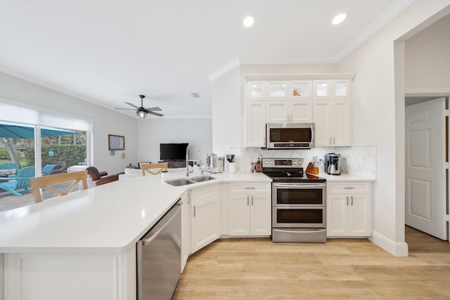 kitchen with white cabinetry, kitchen peninsula, and stainless steel appliances