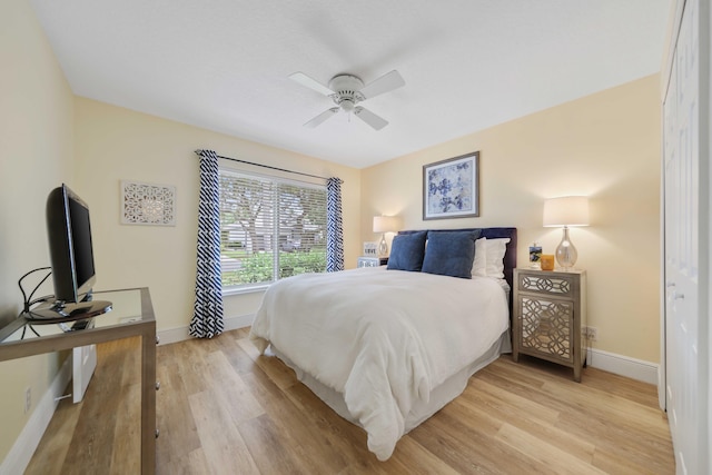 bedroom with ceiling fan, light wood-type flooring, and a closet