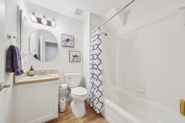 full bathroom featuring vanity, shower / bath combo, hardwood / wood-style flooring, toilet, and a textured ceiling