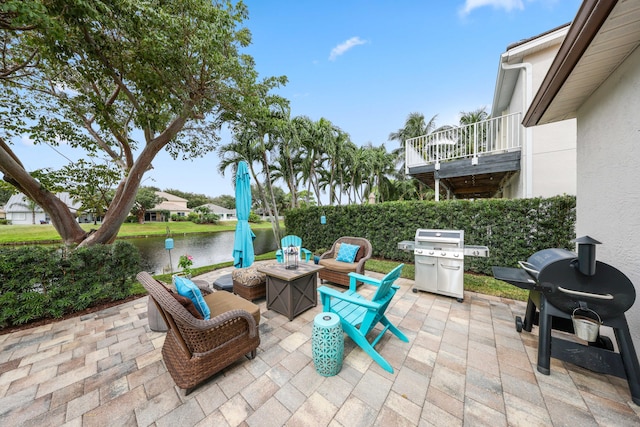 view of patio / terrace with a water view, a fire pit, and a grill