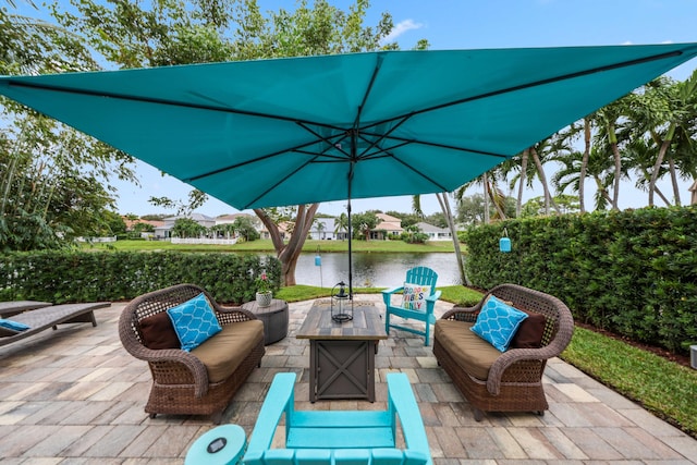 view of patio / terrace featuring a water view and an outdoor living space with a fire pit