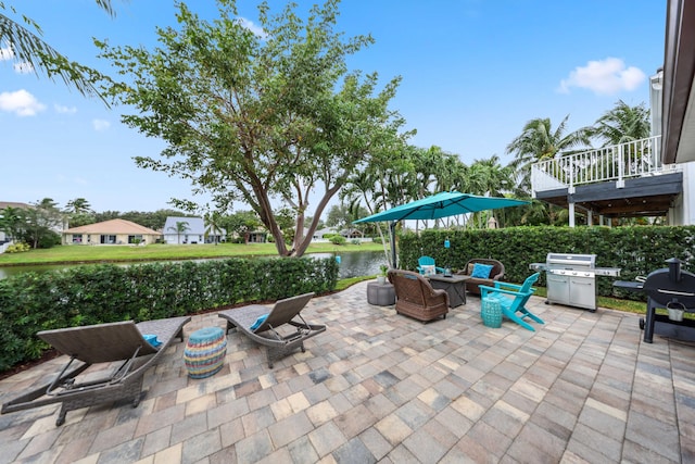 view of patio / terrace with a water view and a grill