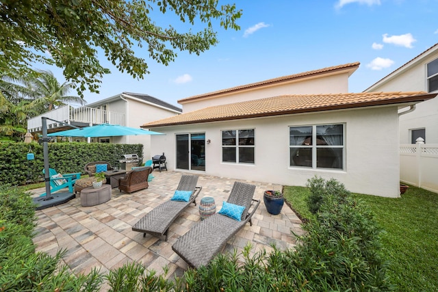 rear view of property with a patio and an outdoor hangout area