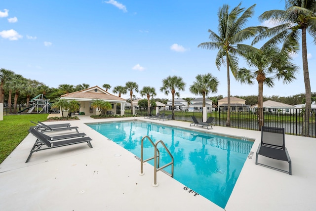 view of pool with a patio and a water view