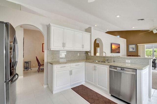 kitchen featuring kitchen peninsula, decorative backsplash, stainless steel appliances, sink, and white cabinets