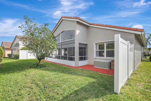 back of house with a sunroom and a yard