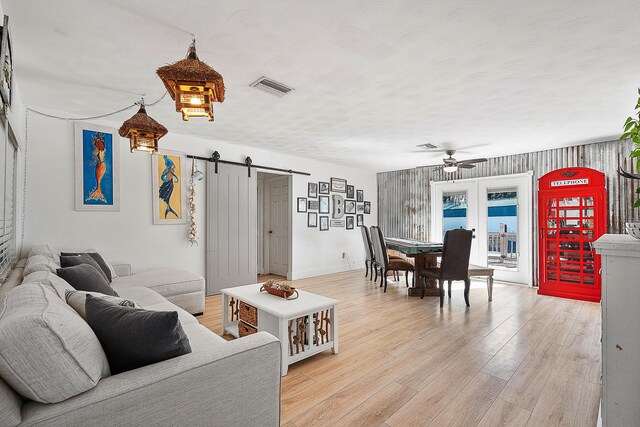 living room featuring a barn door and light hardwood / wood-style floors