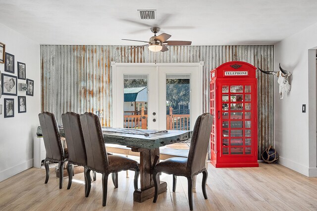 living room featuring a barn door, ceiling fan, and light hardwood / wood-style flooring