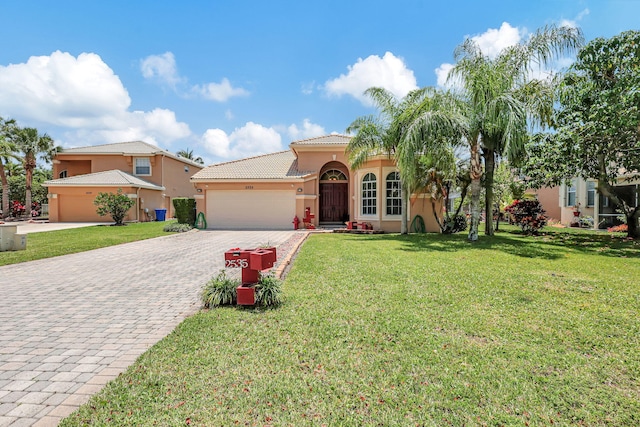 mediterranean / spanish-style home featuring a garage and a front lawn