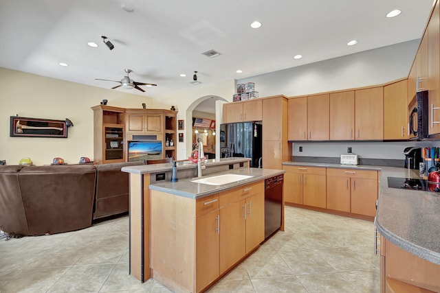 kitchen with light brown cabinetry, ceiling fan, a kitchen island with sink, sink, and black appliances