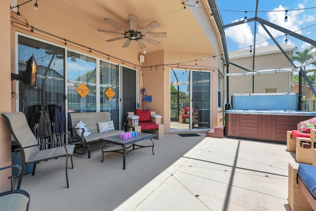 view of patio with a hot tub, ceiling fan, and a lanai