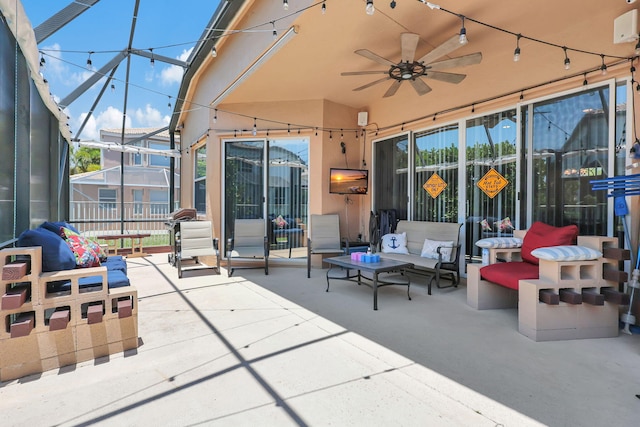 view of patio / terrace with an outdoor hangout area, glass enclosure, and ceiling fan