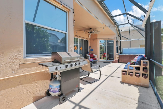 view of patio featuring glass enclosure, a hot tub, ceiling fan, and a grill