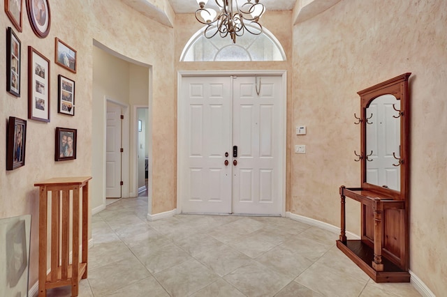 foyer featuring a chandelier, a high ceiling, and light tile patterned floors