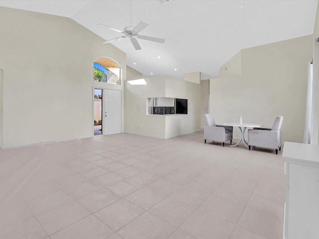 unfurnished living room featuring high vaulted ceiling, ceiling fan, and light tile patterned flooring