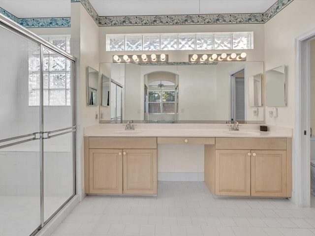 bathroom featuring tile patterned floors, vanity, toilet, and a shower with door