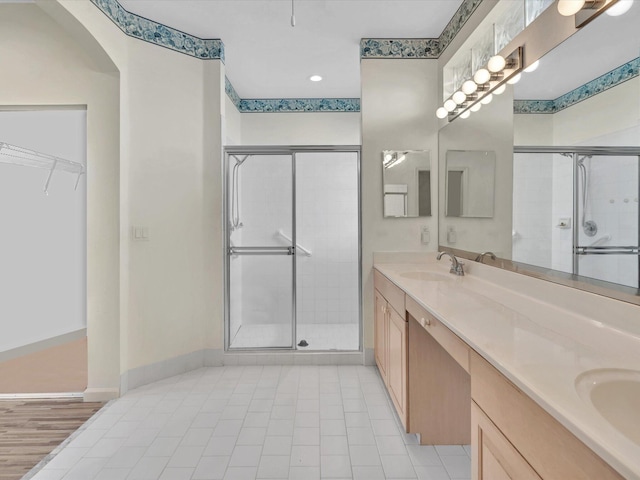 bathroom with tile patterned flooring, vanity, and a shower with shower door