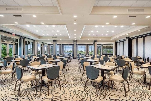 dining room featuring french doors, a tray ceiling, and light colored carpet