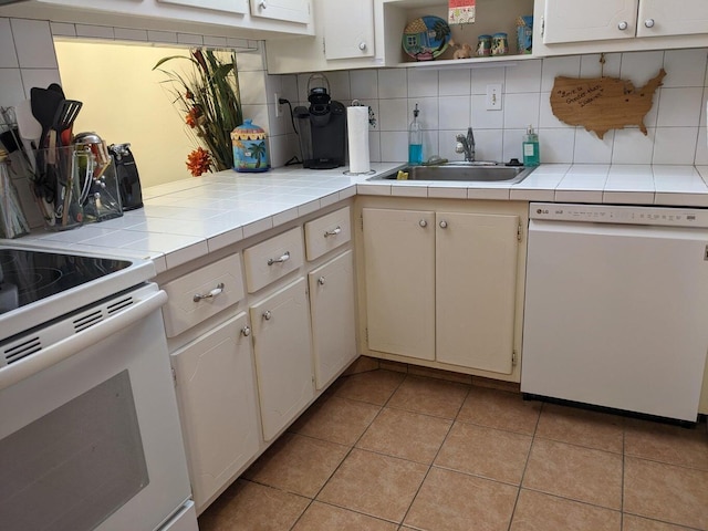 kitchen featuring sink, tile countertops, white appliances, and backsplash