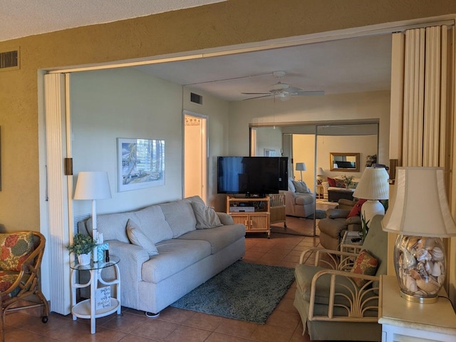 living room featuring ceiling fan and tile patterned floors