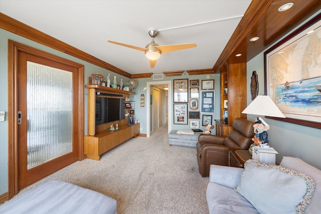 carpeted living room with ceiling fan and crown molding