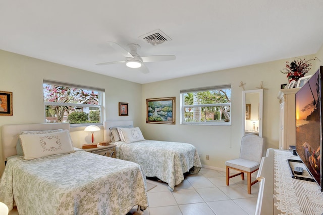 bedroom featuring ceiling fan, light tile patterned floors, and multiple windows