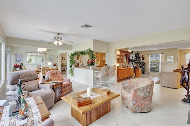 tiled living room featuring ceiling fan and sink