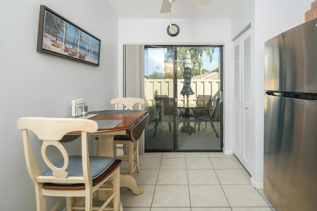 tiled dining space with ceiling fan and a textured ceiling